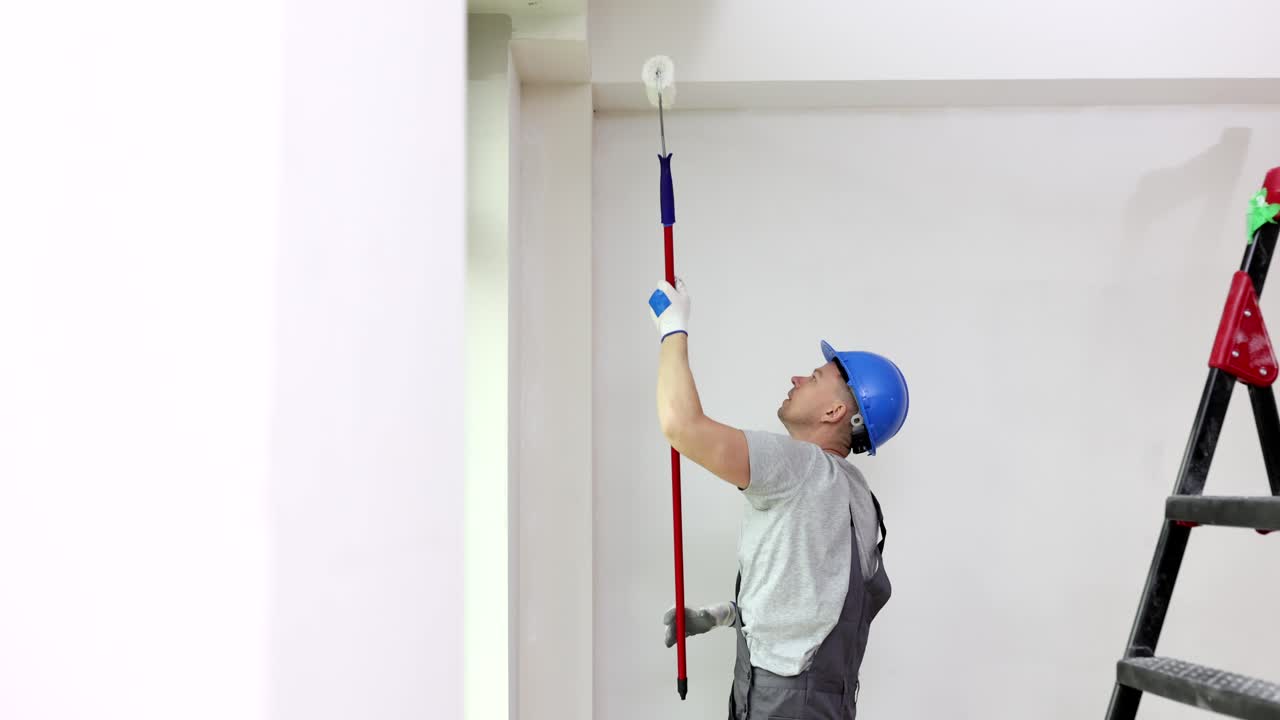 Painter painting a wall with a paint roller