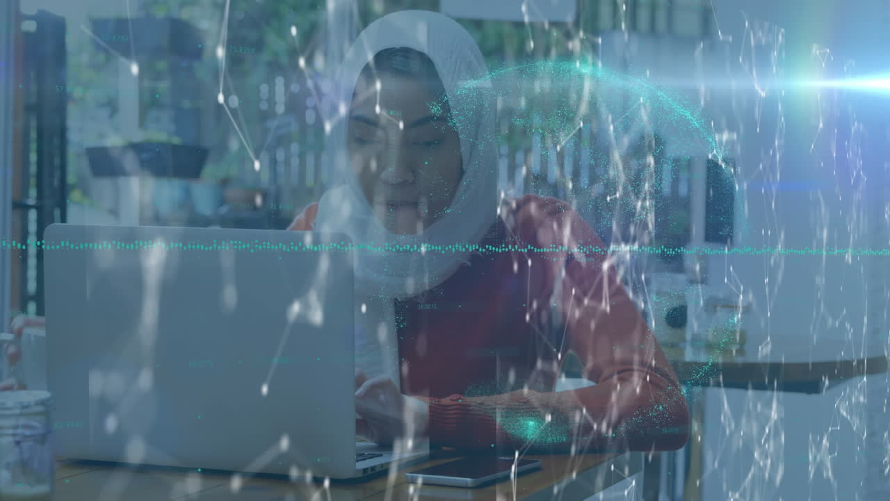 Globe of network of connections against woman in hijab drinking coffee while using laptop