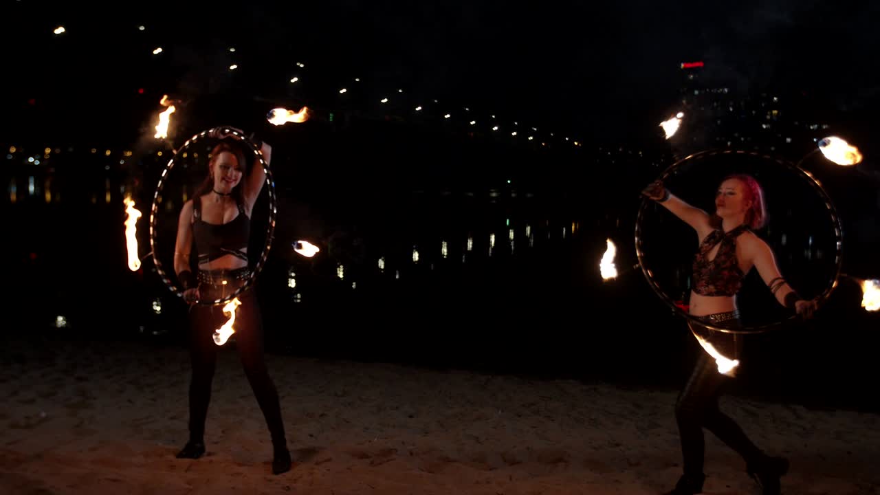 bonitas niñas de fuego trabajando con aros de fuego al aire libre