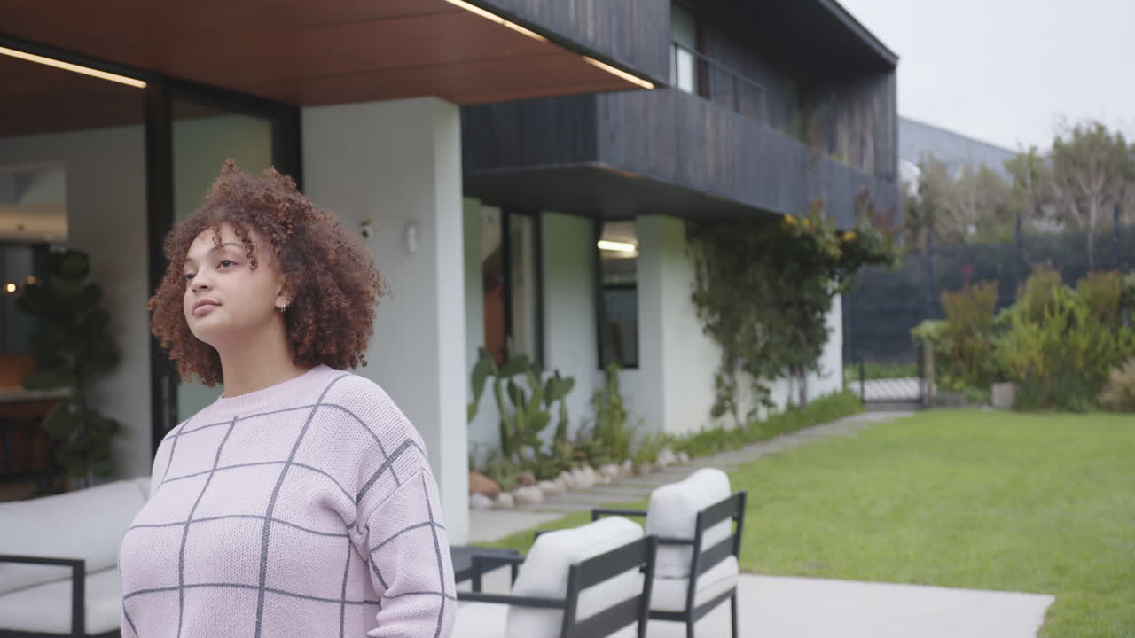 Walking outdoors, woman in casual wear enjoying fresh air near modern house, copy space