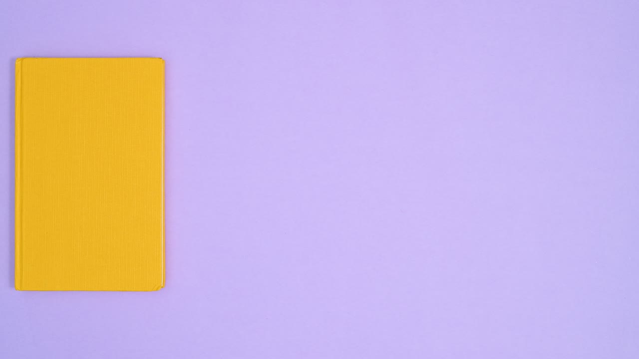 libro vintage retro de tapa dura amarilla se mueve a la izquierda a la derecha en el tema púrpura.