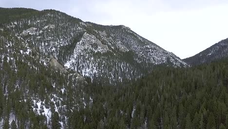 aerial - camera dolly's toward rocky forest mountain side