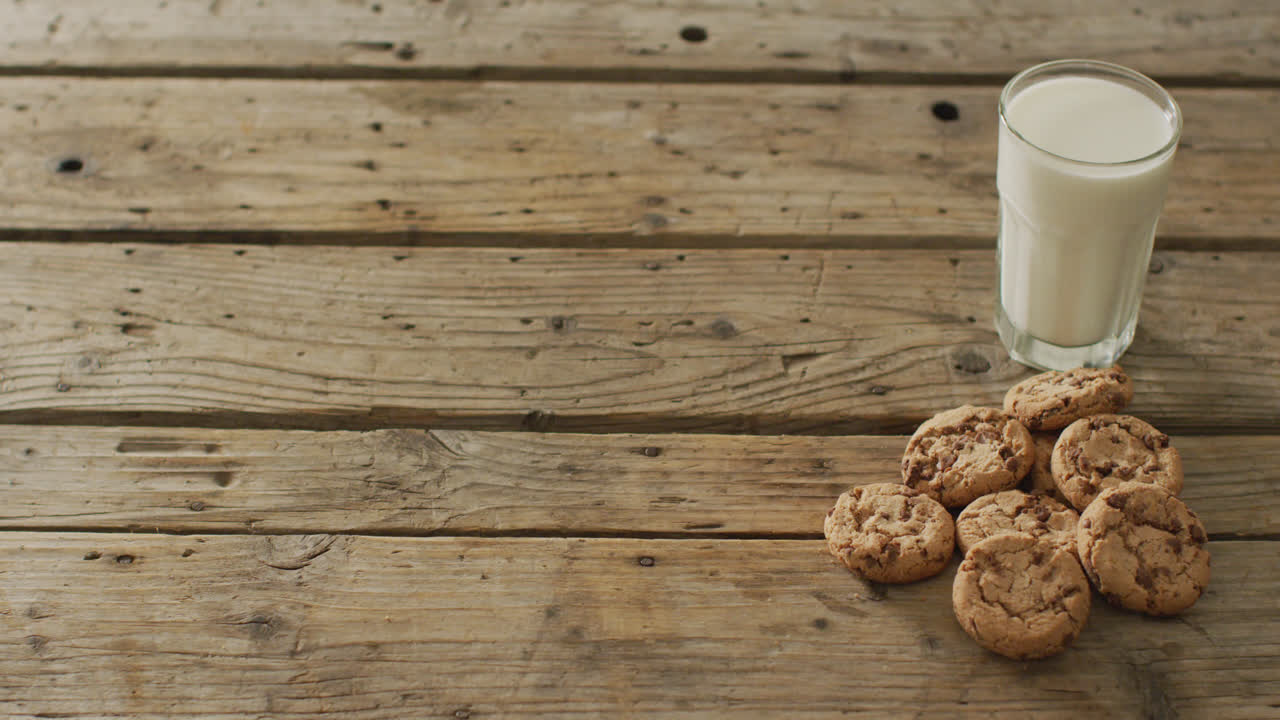 Video of biscuits with chocolate and milk on wooden background