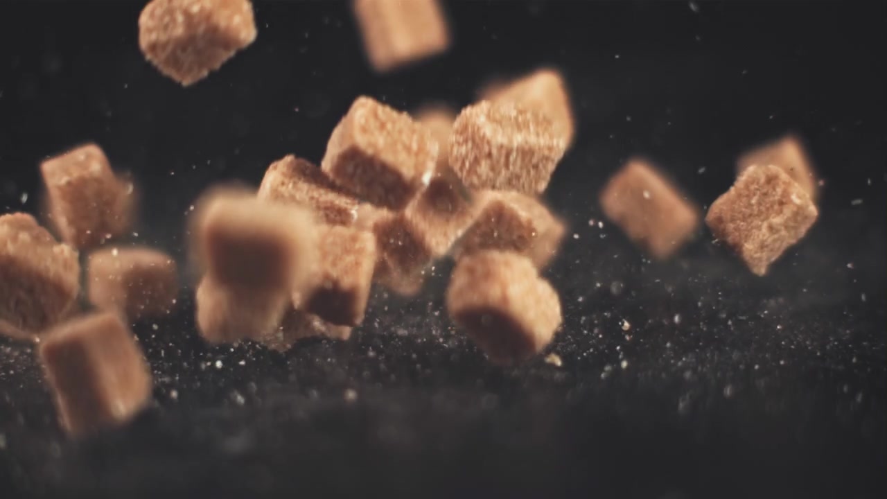 Brown Sugar Cubes Falling in Slow Motion on a Dark Background