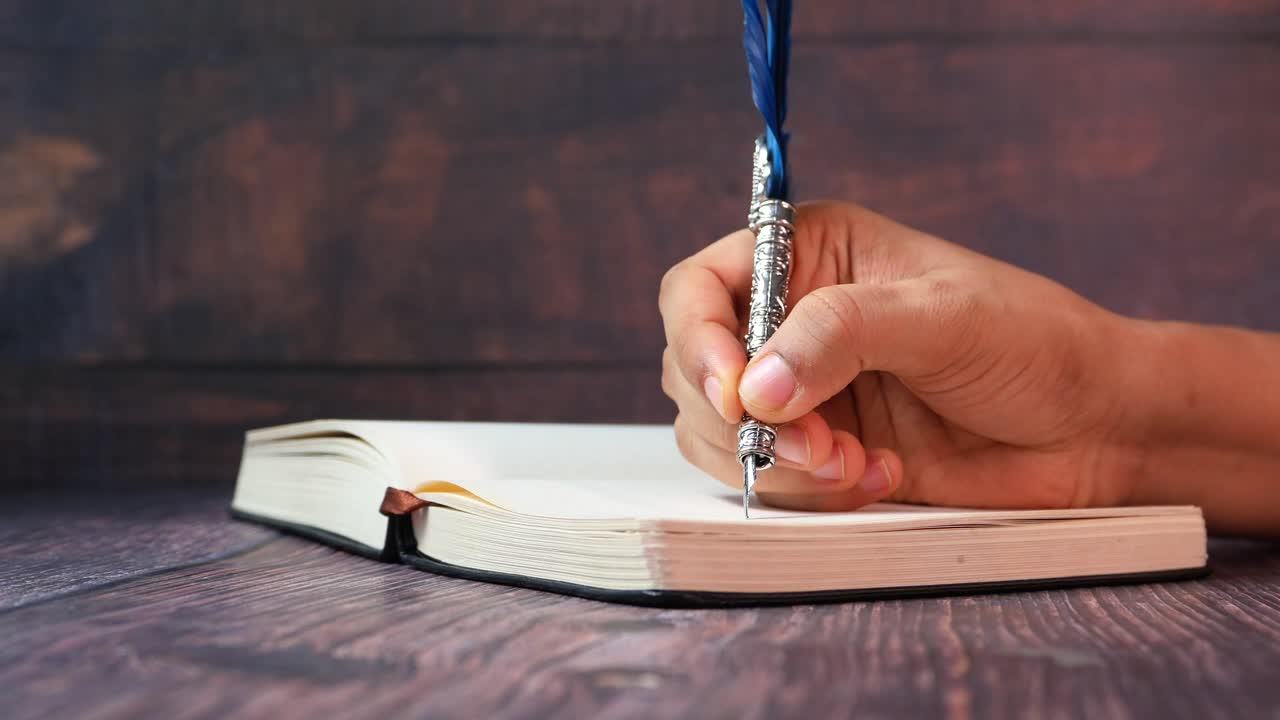 Hand Writing in a Notebook with a Vintage Feather Pen