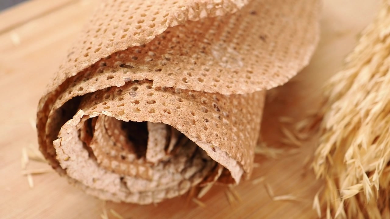 Kaulittu täysjyvä-näkkileipä kauran korsilla puulaudalla