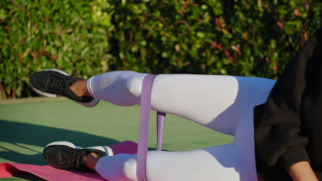 woman doing leg workout with resistance band outdoors