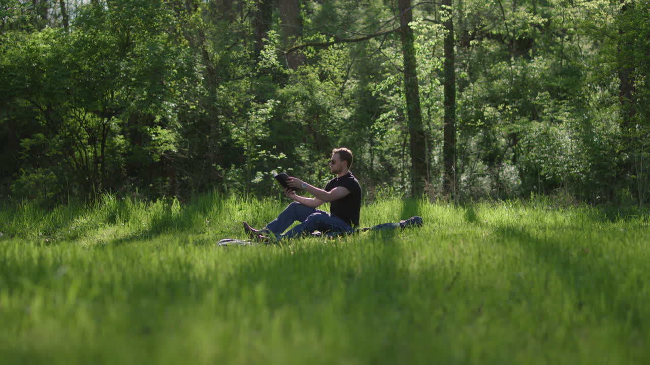 Man reading in a park on a sunny day