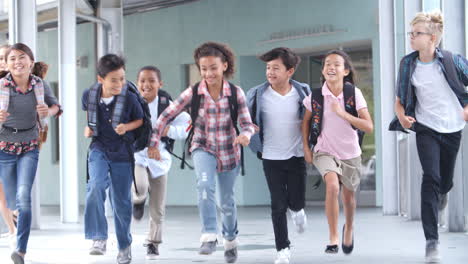 group of 5th grade school kids running in a school corridor