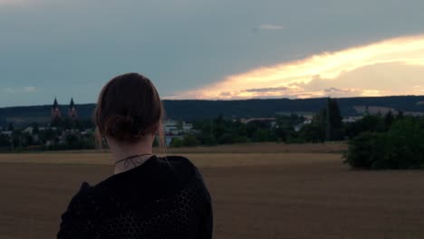 beautiful girl pointing her finger at the horizon, then turns and smiles at the camera