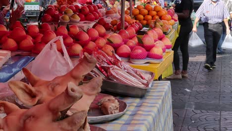 los compradores pasan por un colorido puesto de frutas