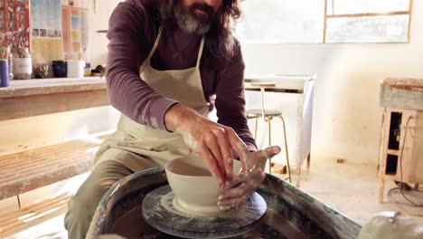 male potter making pot