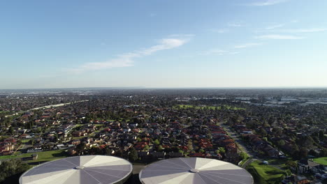 static aerial perspective of water storage tanks as birds fly around the drone numerous times within close proximity