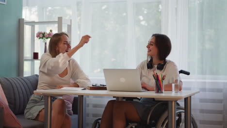 mujeres alegres sonriendo dando cinco después de completar la tarea
