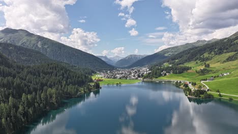 aerial - timelapse over davos and reflecting lake, surrounded by alps