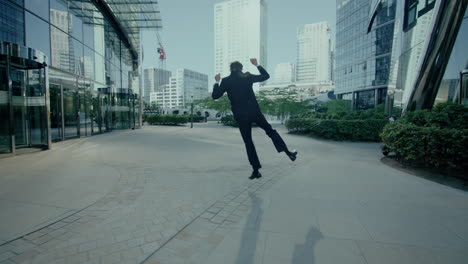 Siguiente-Foto-De-Un-Hombre-De-Traje-Caminando-Felizmente-Afuera-Del-Edificio-De-Oficinas-Durante-La-Noche