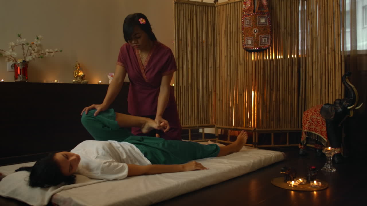 Therapist giving a traditional chinese massage of feet. Professional therapist giving a traditional chinese massage of feet to a woman in a chinese therapeutic