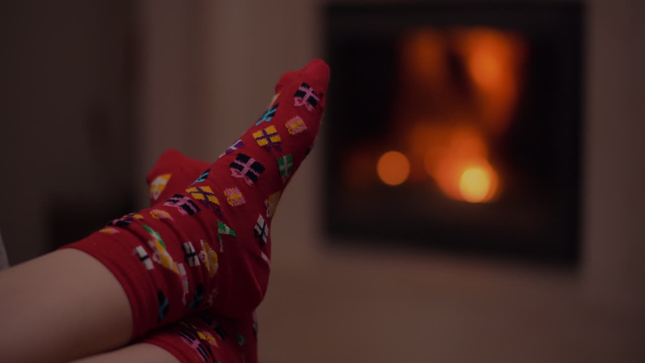Piedi Comodi con Calzini Festivi Accanto a un Camino Caldo