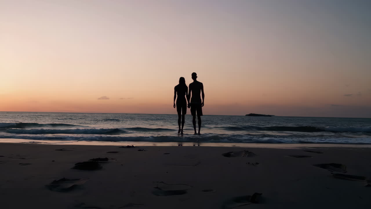 해가 지는 동안 해변을 고 있는 부부