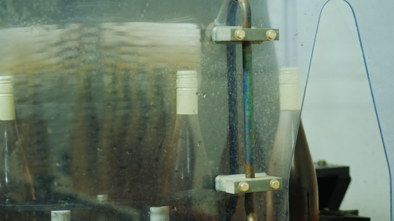 botellas de vino que se mueven a lo largo del transportador hasta el automóvil donde se lavan con agua