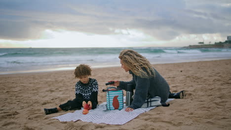 Happy-kid-looking-spyglass-on-family-picnic.-Single-parent-giving-toy-to-son