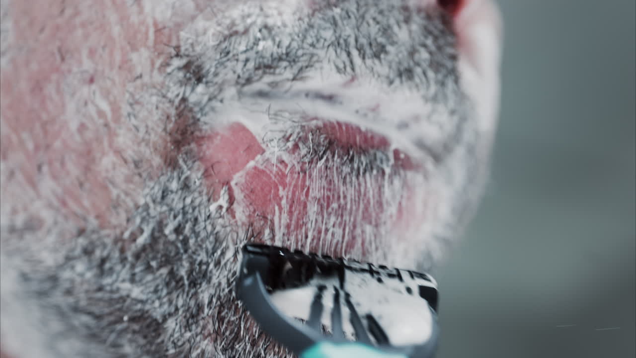Primo piano di un uomo che si rade la barba con un rasoio
