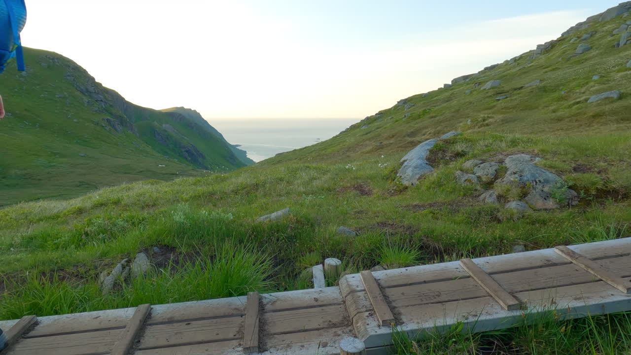 excursionista caminando sobre vigas de madera en una ruta de senderismo que pasa con una vista panorámica, tiro estático