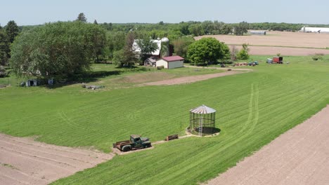 close-up descending aerial shot of an empty corn silo and old farm truck in the rural fields of minnesota