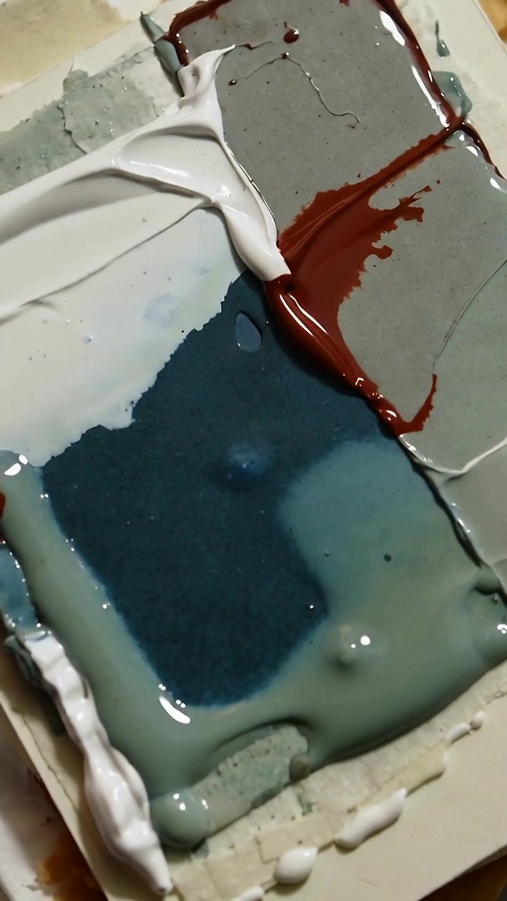 Video verticale: Pannello campione di vernice che si sposta, mostrando crema che si sparge su un tavolo e una pozza lucida color verde acqua.