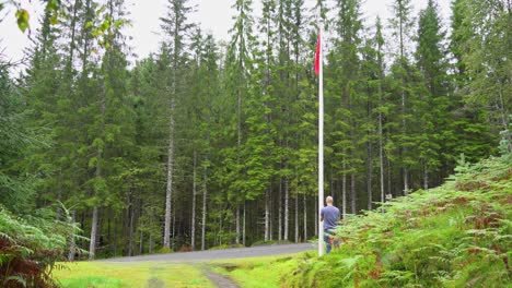 Man-hoisting-red-flag-to-warn-people-that-shooting-is-about-to-start-at-shooting-range---Caution-symbol