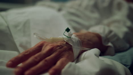 Female-patient-lying-bed-in-clinic-ward.-Close-up-hand-with-IV-therapy-tube.