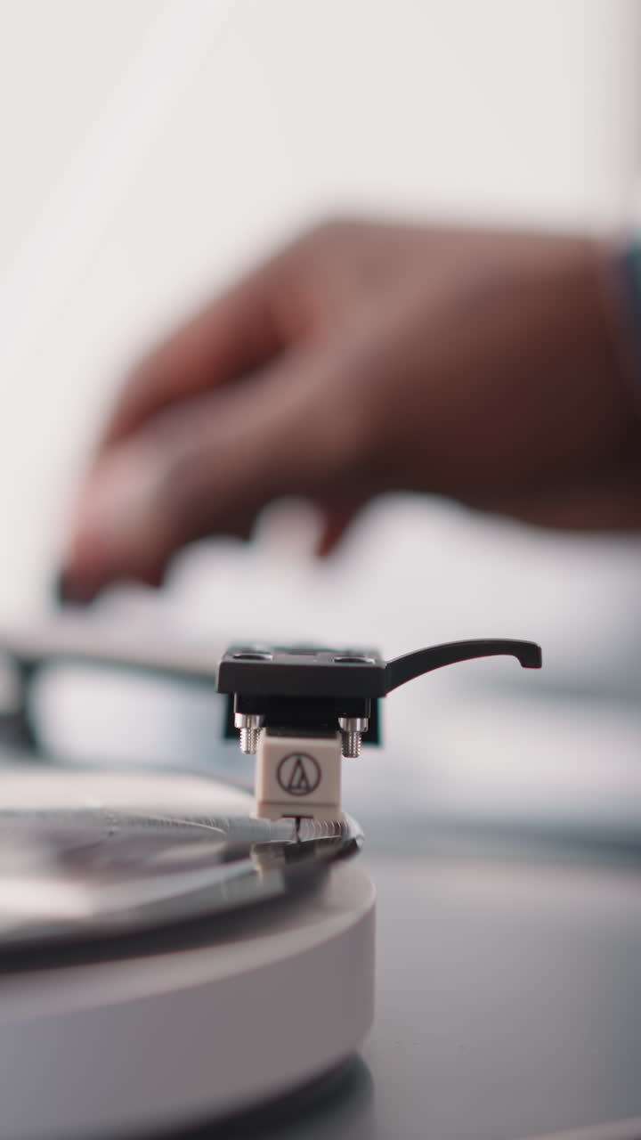 Man puts phono stylus on vinyl disk in turntable. Male music lover fills day with joy of listening to music on vintage device. Old-school collectible vinyl