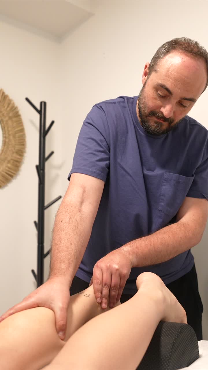 Male Therapist Massaging a Woman's Leg and Ankle