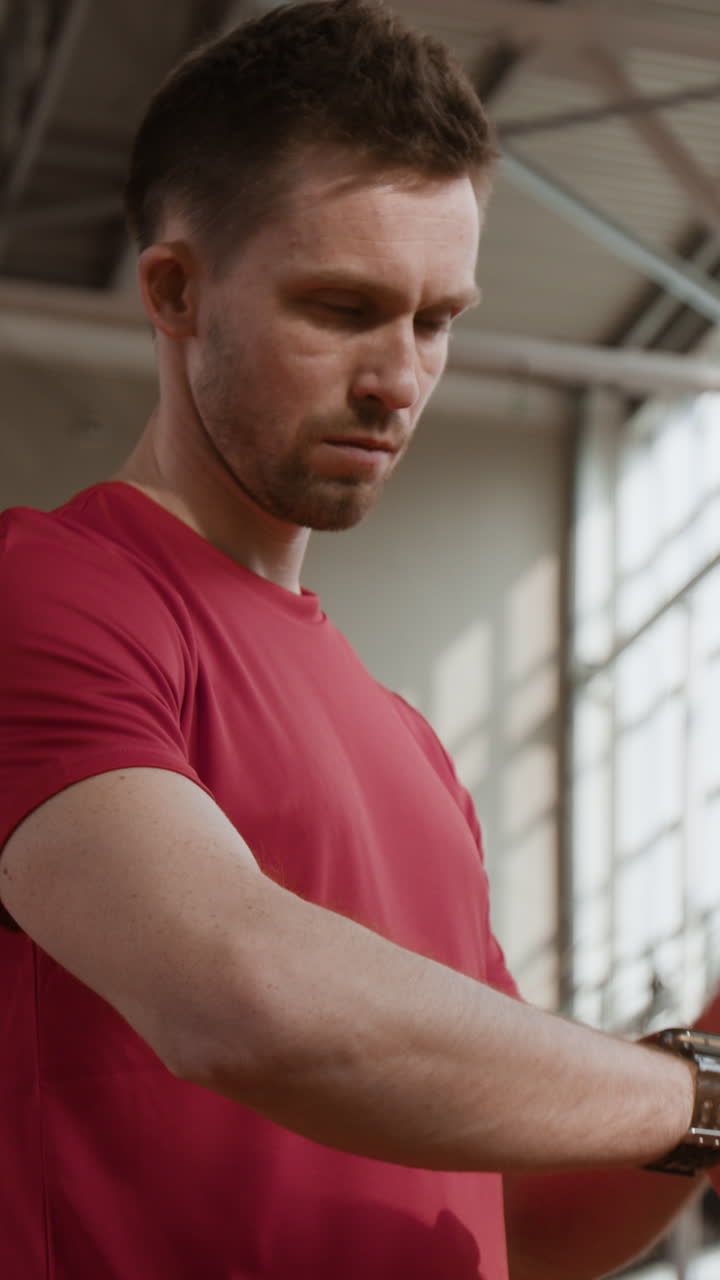 Man in red shirt checking his smart watch or fitness tracker