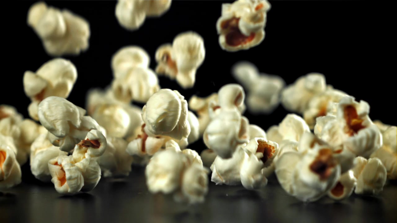 Popcorn che cadono al rallentatore su sfondo nero