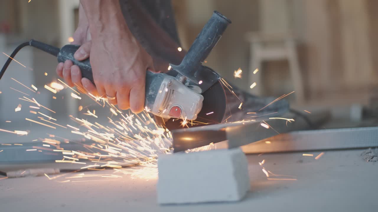 hombre trabaja sierra circular. chispas vuelan de metal caliente. hombre trabajó duro sobre el acero. primer plano en cámara lenta en el garaje