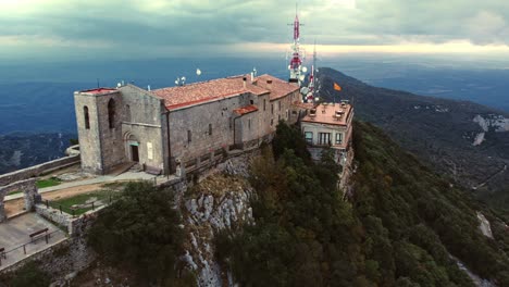 drone shot orbiting historic and beautiful church in mountains of spain