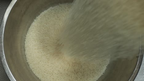 cuenco de arroz mientras se llena con arroz blanco de grano largo crudo