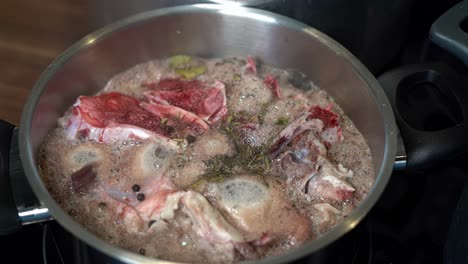 bone broth, seasoned with herbs and spices, simmering in pot on stove top