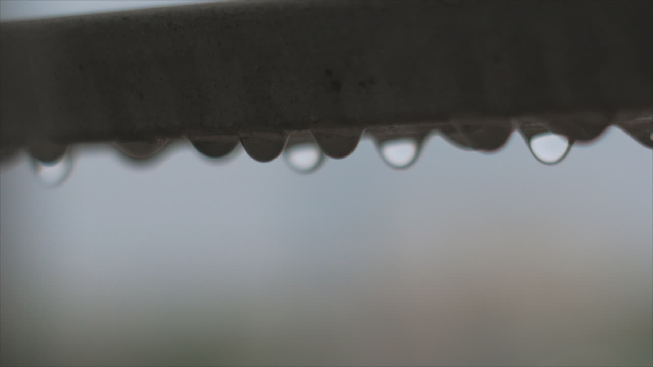 Close up shot rain drops waving on steel balcony guard