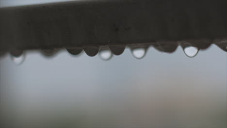close up shot rain drops waving on steel balcony guard