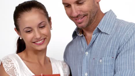 una pareja feliz sosteniendo una casa modelo