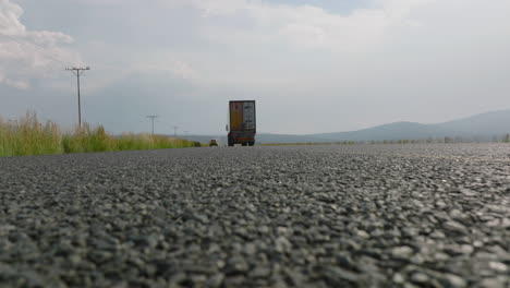 Low-Angle-View-Von-Fahrzeugen,-Die-Auf-Der-Straße-Fahren.-Detaillierte-Aufnahme-Der-Rauen-Struktur-Der-Asphaltstraßenoberfläche.-Südafrika
