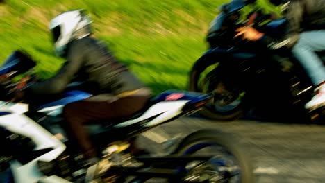 two motorcyclists dressed up in complete racing attires racing over the tracks on sports bike. slow motion.
