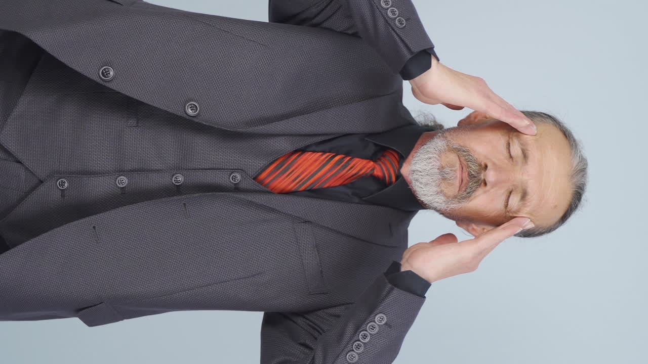 Vertical video of Old businessman with headache.