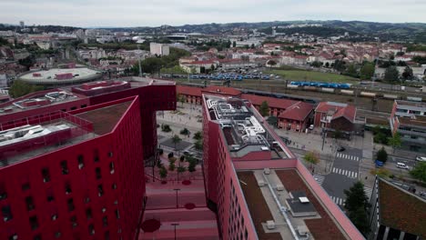 drone-shot-over-Saint-Etienne-business-district-and-Chateaucreux-train-station-with-red-design-building-in-the-foreground-during-the-day