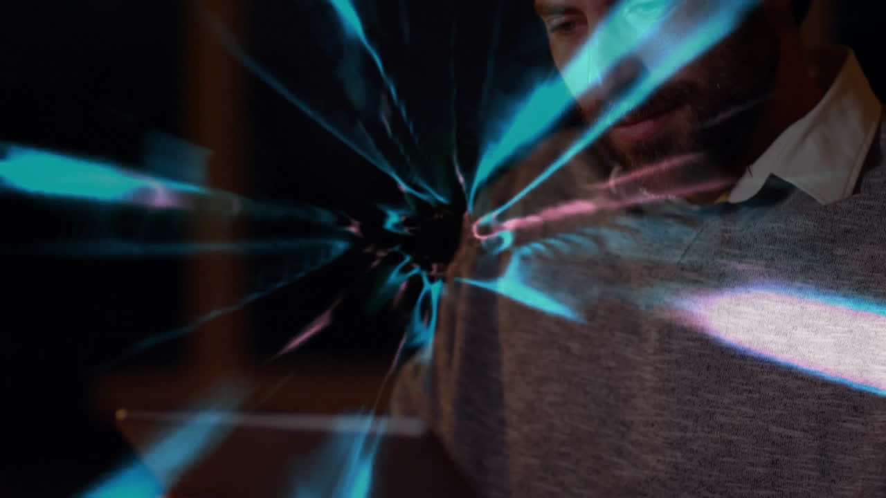 Man holding device, projecting electric blue energy arcs indoors, showcasing technology