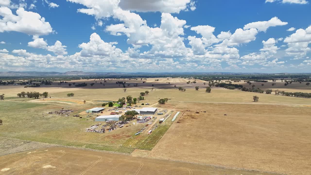 Aerial orbit of farm buildings and rubbish surrounding a farm in NSW Australia