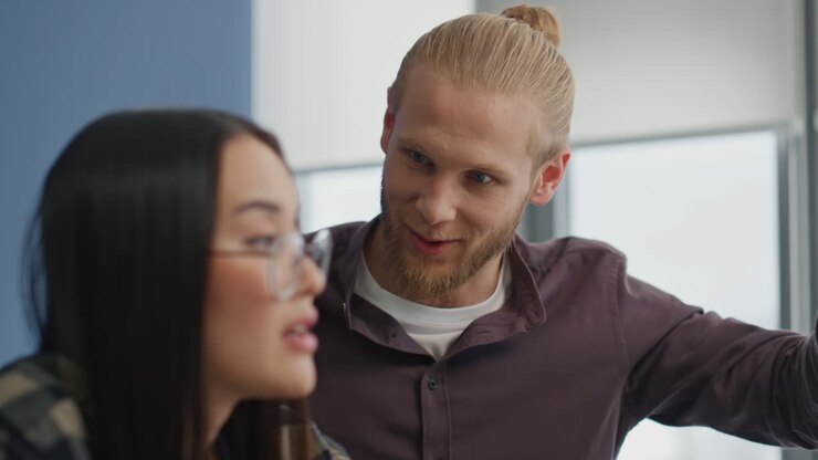Closeup colleagues brainstorming at creative office. Blonde man sharing ideas