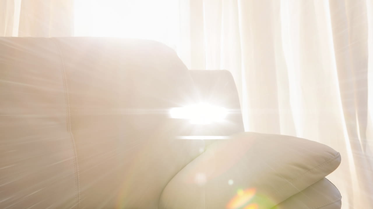 집에서 소파 소파와 커튼에 대한 빛의 밝은 반점